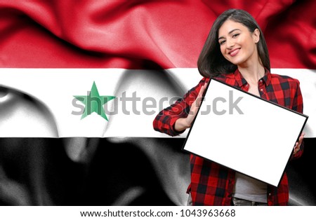 Woman holding blank board against national flag of Syria