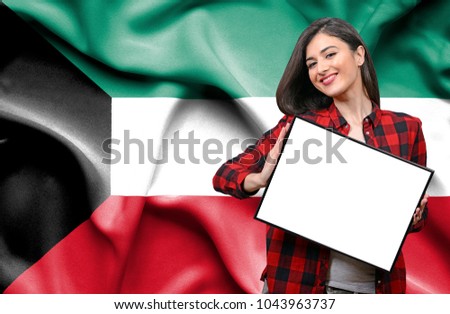 Woman holding blank board against national flag of Kuwait