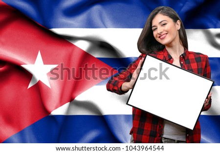 Woman holding blank board against national flag of Cuba