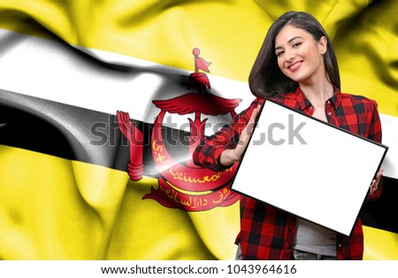Woman holding blank board against national flag of Brunei