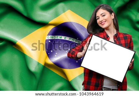 Woman holding blank board against national flag of Brazil