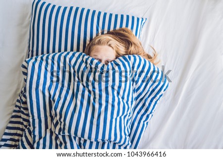 Beautiful young woman lying down in bed and sleeping. Do not get enough sleep concept