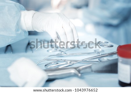 Important things. Clean useful surgical instruments being on the table and taking by a nurse. Royalty-Free Stock Photo #1043976652