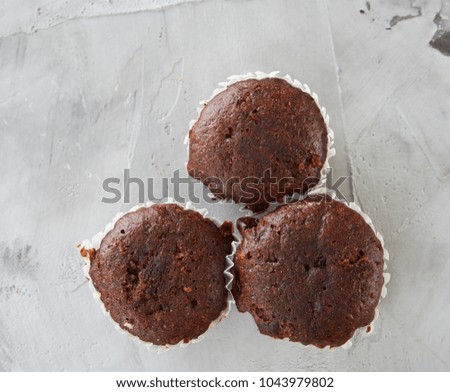Tasty muffins arranged in pattern on light textured background, close-up, shallow depth of field, selective focus.