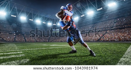 American football players preforms an action play in professional sport stadium Royalty-Free Stock Photo #1043981974