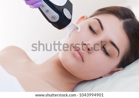 Doctor woman making to patient laser skin resurfacing in aesthetic medicine.