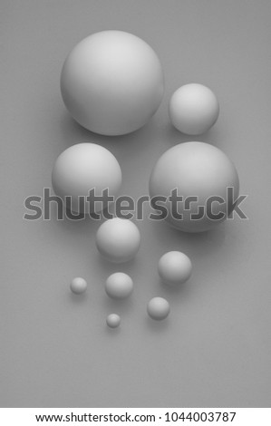 closeup top view group of assorted industrial ceramic balls bearings on grey background