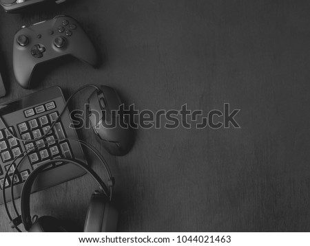 gamer workspace concept, top view a gaming gear, mouse, keyboard, joystick, headset on black table background with copy space.