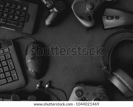gamer workspace concept, top view a gaming gear, mouse, keyboard, joystick, headset on black table background with copy space. Royalty-Free Stock Photo #1044021469