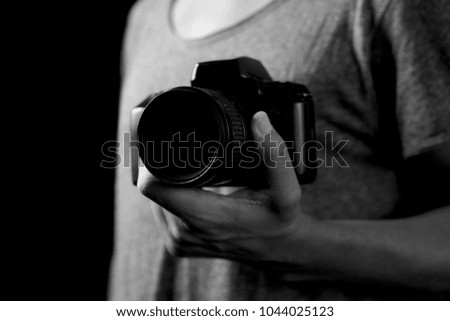 closeup of a young caucasian man with a reflex camera in his hand, in black and white