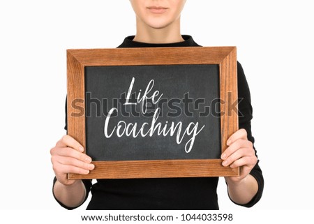 Cropped view of woman holding board with lettering life couching isolated on white