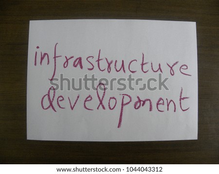 Text infrastructure development hand written by red oil pastel on white color paper