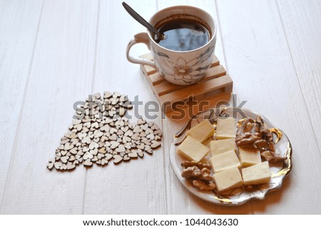 Morning coffee, tasty breakfast and decorative wooden hearts on the table. Hygge style background. 