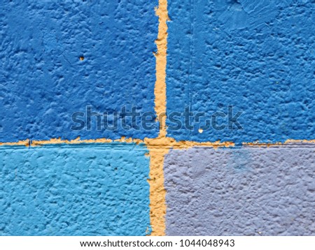 Abstract composition of squares of blue color of various shades, depicted on the wall.