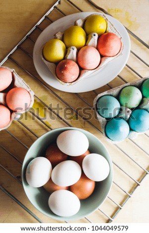 Dyeing eggs for Easter holidays, coloring with different color and tonality using food colorant over a gray concrete background