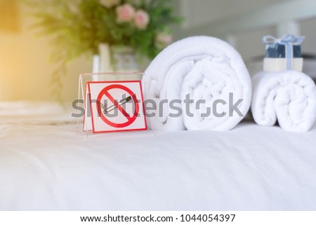 No smoking signs white plastic on bed at hotel