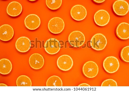 Background of half cut oranges on orange background Royalty-Free Stock Photo #1044061912