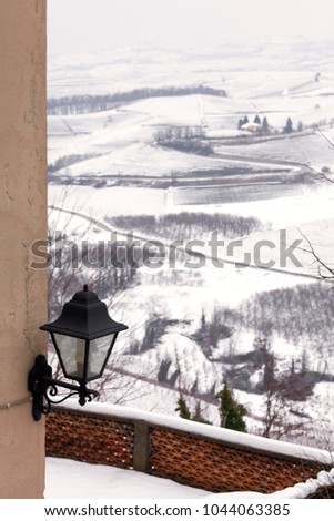 Winter view of the vineyards, covered by the snow, in the hilly region of Langhe (in the southern area of Piemonte Region, Northern Italy), in the village of Castiglione Falletto (Cuneo Province).