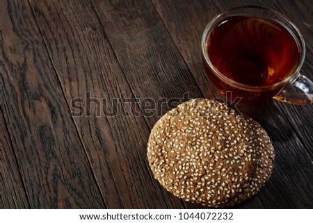 Cup of tea with a couple of cookies on a wooden background, top view, selective focus