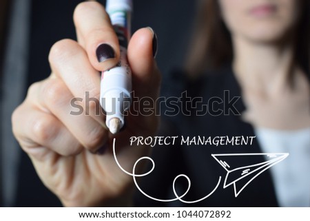 The businessman writes an inscription with a white marker:PROJECT MANAGEMENT