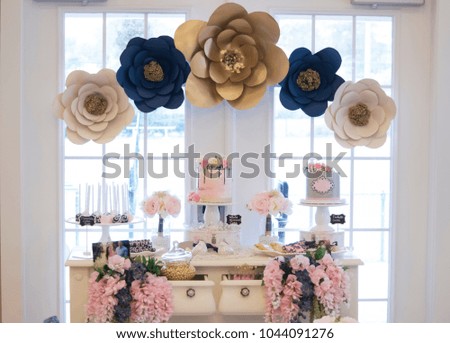 The dessert table for a wedding with the colors pink, champagne, and navy
