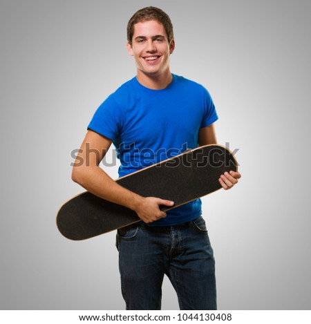 Happy Man Holding Skateboard against a grey background