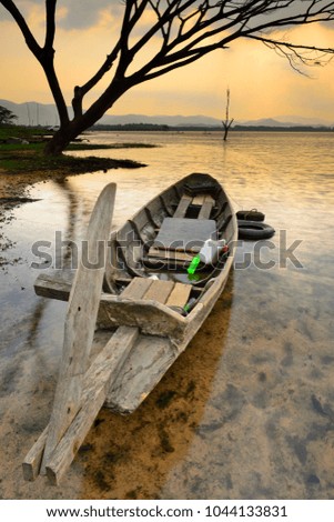Beautiful scenery of wooden fishing boat on lake at sunrise. Fishery boat on lake. Old wooden boat.