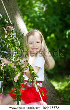 Bright summer berry party in park. Cute girl on the swing