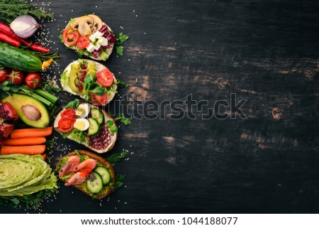 Set Burger, sandwich. with quail eggs, cucumbers and corn, salami and seafood. On a wooden background. Top view. Copy space.