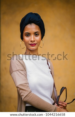 Portrait of a young, attractive Muslim business woman. She is wearing a turban (hijab, headscarf) and is elegantly dressed in business casual. She is tall, slim and elegant. 