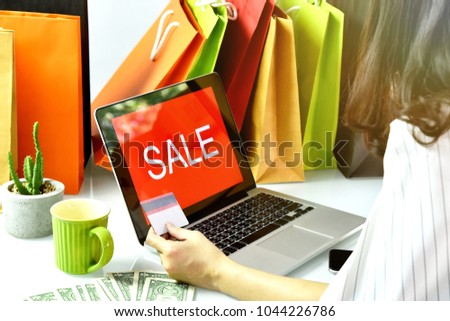 Online shopping, Shopaholic woman holding credit card, Sale promotion sign on laptop computer, E-business commercial concept.