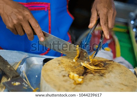 Traditional way of preparing grilled squid using chopper knife. Picture of traditional thai cuisine made of fresh ingredients taken in restauranti.