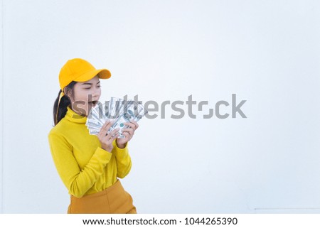 Portrait of beautiful asian woman in yellow cloths on dirty white wall,Hipsters girl wear yellow hat  take a picture,Thailand people have a lot dollar money in hand