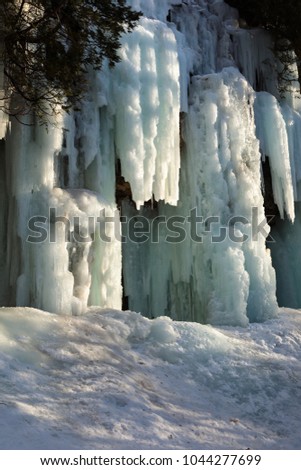 Ice caves and ice curtains form along the Pictured Rocks escarpment on Sand Point Road in Munising Michigan. These ice curtains are popular for ice climbing enthusiast. 
