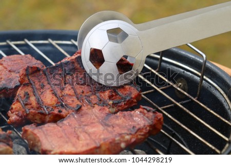 close up of tasty steaks on barbecue grill with Football World Cup tong Royalty-Free Stock Photo #1044298219