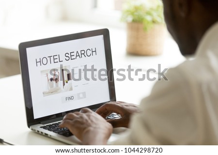 African american man browsing hotel online for business or holiday vacation using web search app on laptop computer website engine, black businessman looking for cheap booking service, rear close up