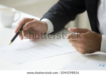 Businessman offering to sign business contract concept, promising good deal convincing to put signature, negotiating pointing on legal document terms, proposing partnership insurance, close up view Royalty-Free Stock Photo #1044298816