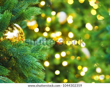 Christmas tree with holiday golden decorations and lights. Space for text. Festive New Year background, selective focus, Christmas fir tree garlands, balls and toys. Illumination