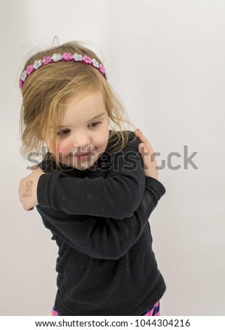 child folding arms against white background 
