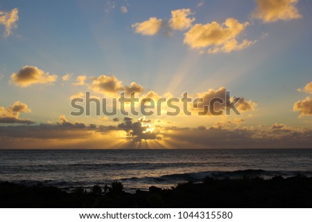 The sun rising over the Atlantic Ocean in Lanzarote, Canary Islands, Spain. Sunburst behind the clouds over the horizon.