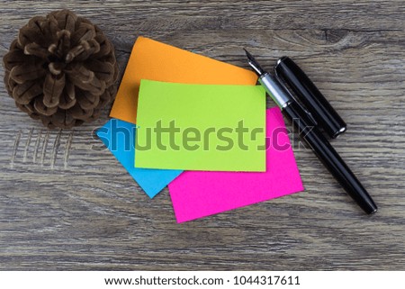 Colorful stick notes on a wooden table with a fountain pen