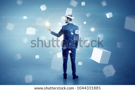 Handsome businessman with vr goggle and falling white cubes around
