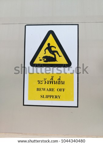 Warning sign "Beware slip" put on wet area. thailand