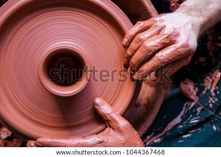 Professional potter making bowl in pottery workshop, studio. Royalty-Free Stock Photo #1044367468