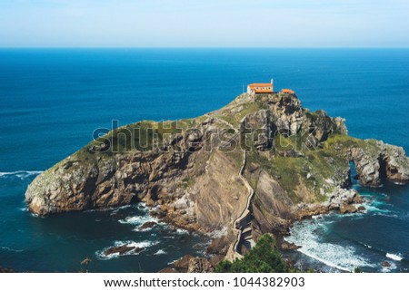 Sea scape on background gaztelugatxe steps sun huan, hipster girl looking on horizon ocean, relax holiday, blank space blue waves view, travel trip on Basque country in Spain, popular place of movies