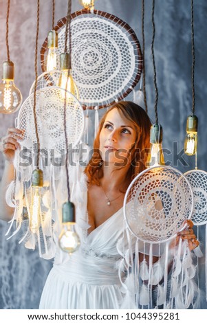 Beautiful woman boho bride in white vintage gown with Dream catcher, concept of occultism and stylized wedding