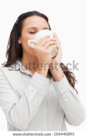 Brunette drinking a hot coffee against white background