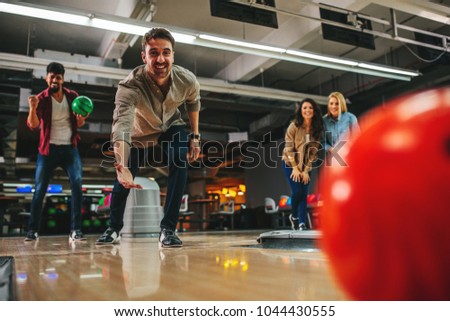 Shot of an attractive young man throwing the bowling ball