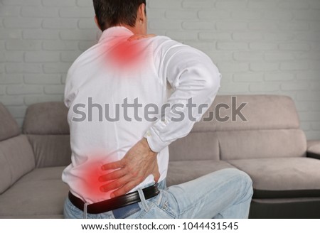 Man suffering from back and neck pain. Incorrect sitting posture problems, Muscle spasm, rheumatism. Pain relief, ,chiropractic concept.