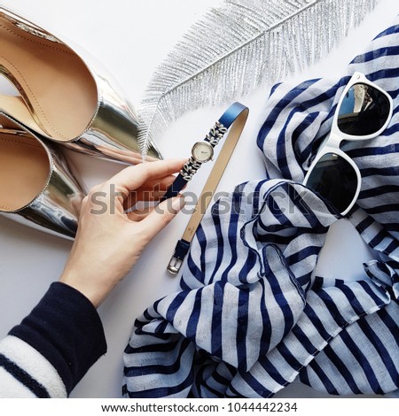 Summer fashion look flat lay with sailor stripes white and blue, watches, sunglasses and silver shoes